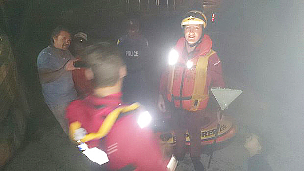 NSRI Bakoven crew holding the garden rake the 'mystery' man used as a paddle out at sea. 